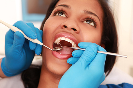 The image shows a dental professional performing oral care on a patient in a clinical setting.