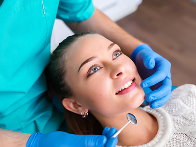 A young woman receiving dental care with a dentist performing the procedure.