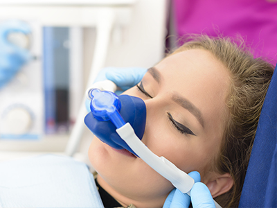 The image shows a person lying down with medical equipment attached to their face, likely in a healthcare setting.